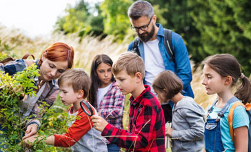 Group of school children with teacher on field trip in nature
