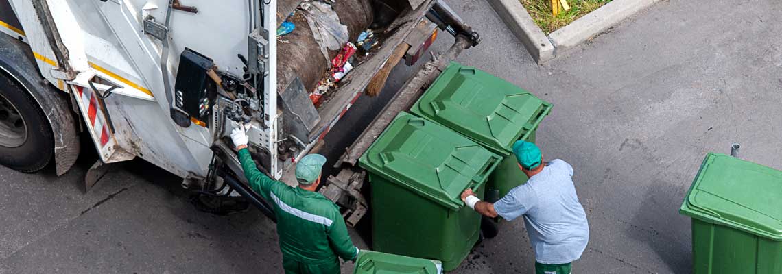 garbage men loading household rubbish in garbage truck