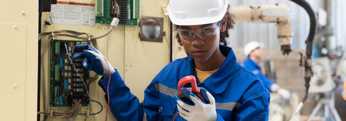 Female electrician checking electric system in the factory