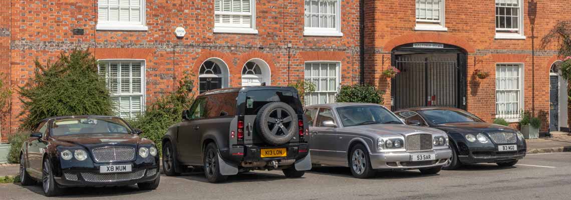 Expensive cars parked outside houses