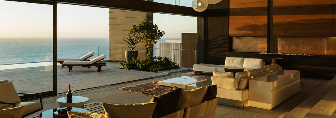  Modern living room with large windows opening onto a terrace overlooking the sea