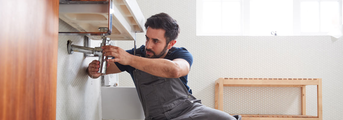 Plumber fixing leaking sink