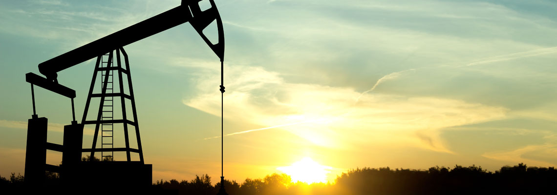 Silhouette of oil rigs against the sunset