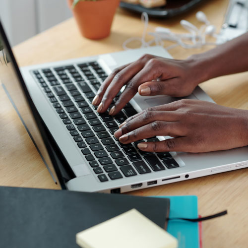 Hands of young woman typing on laptop