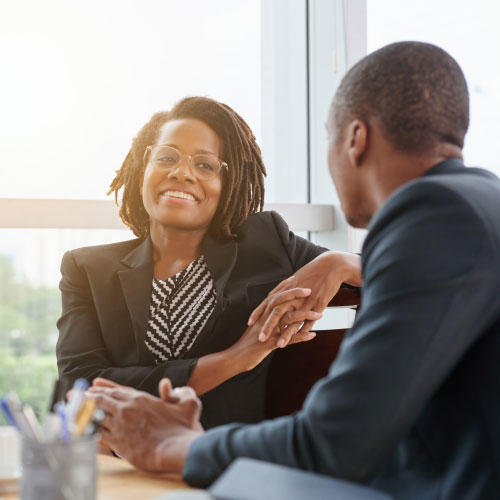 smiling African-American business lady chatting with coworker
