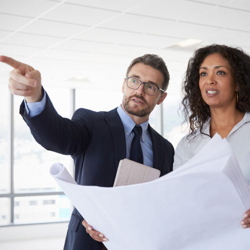 Business people looking at plans in empty building