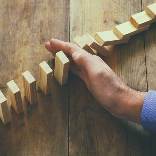 hand stopping the domino effect