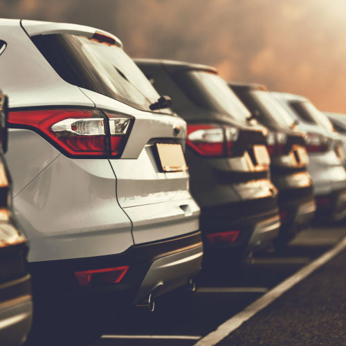 electric cars SUVs parked in row on dealership parking