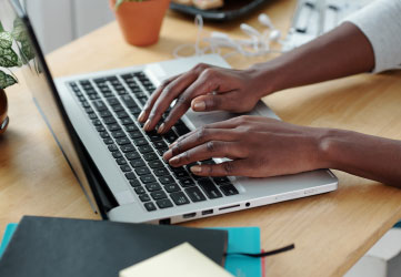 Hands of young woman typing on laptop