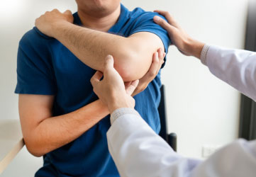 Chiropractor examining from shoulder pain in clinic medical office