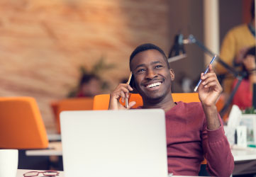 businessman on the phone sitting at the computer in his startup office