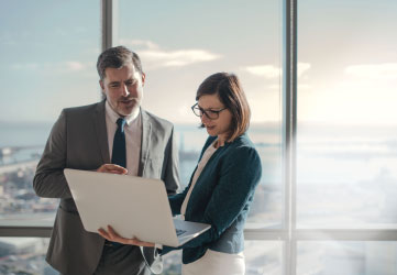 Businessman and businesswoman using a laptop