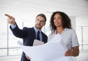 Business people looking at plans in empty building