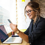 Young woman using her mobile and laptop