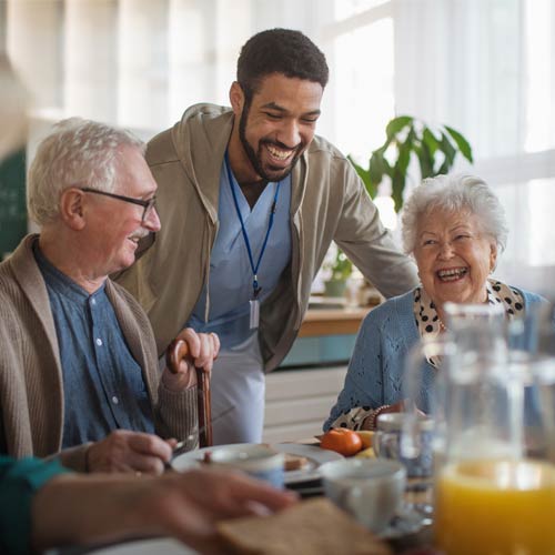 Group of cheerful seniors enjoying breakfast in nursing home care centre