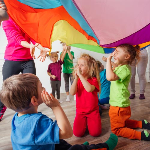 Close up view of children under huge rainbow cover