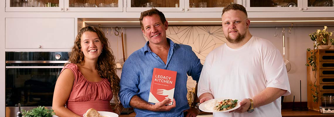 Matt Tebbutt, Edd Wilson and Lizzie Connick in a kitchen with the Legacy Kitchen book