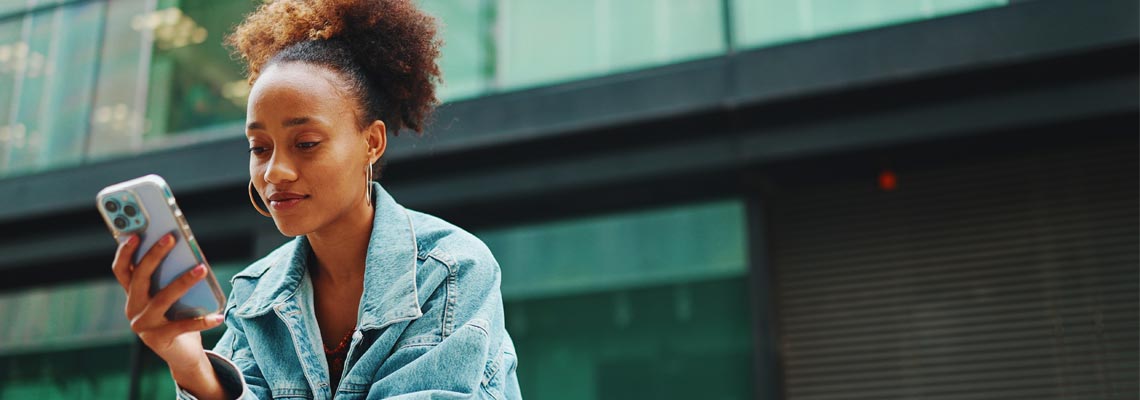 woman sitting on a bench looking at mobile phone