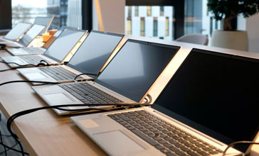Row of laptops being prepared and set up