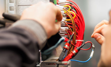 Closeup of electrician working with electric cable wires