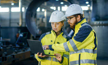 Male and female industrial engineers in hard hats