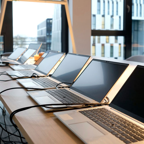 Row of laptops being prepared and set up