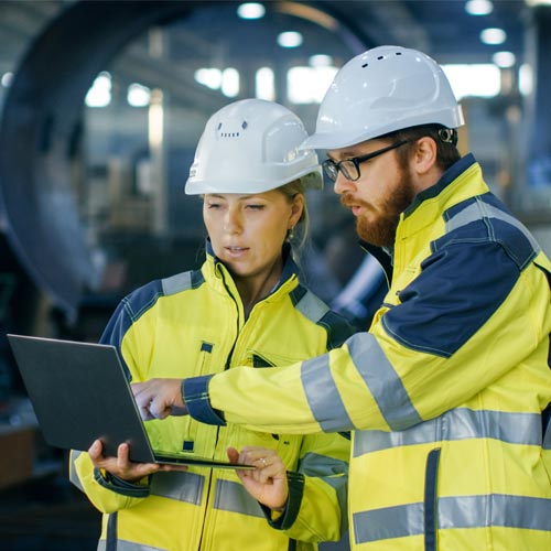 Male and female industrial engineers in hard hats