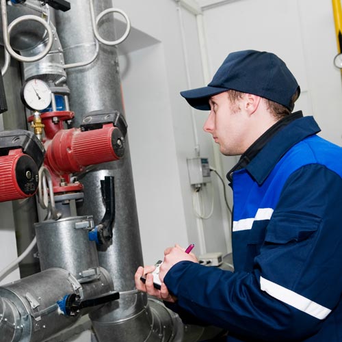 maintenance engineer checking technical data of heating system equipment