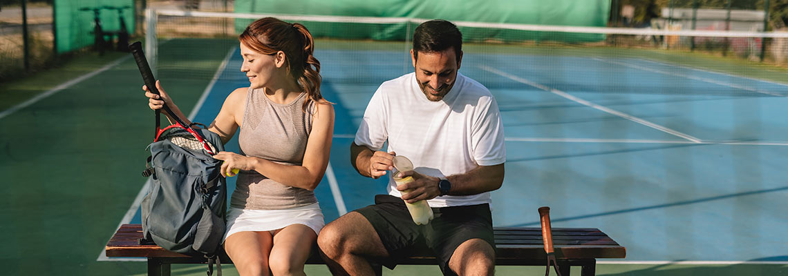 Man and woman setting up to play tennis