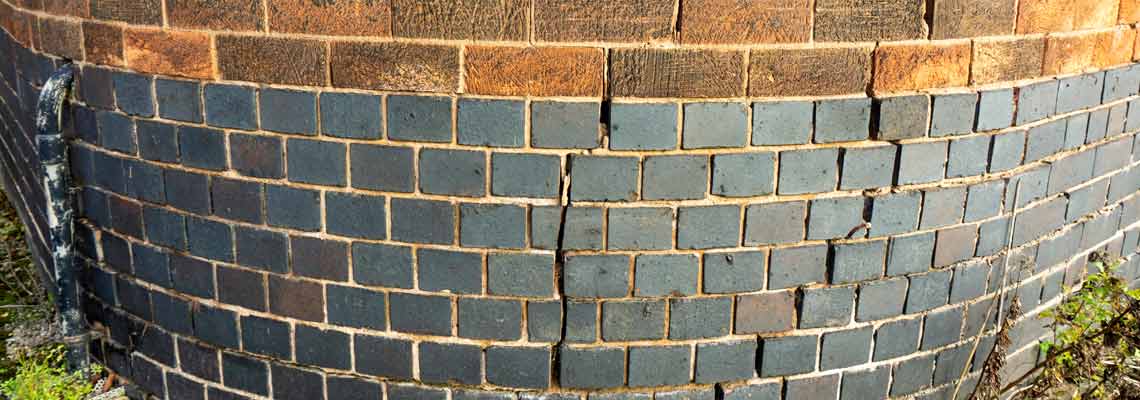Large cracks in a round brick wall