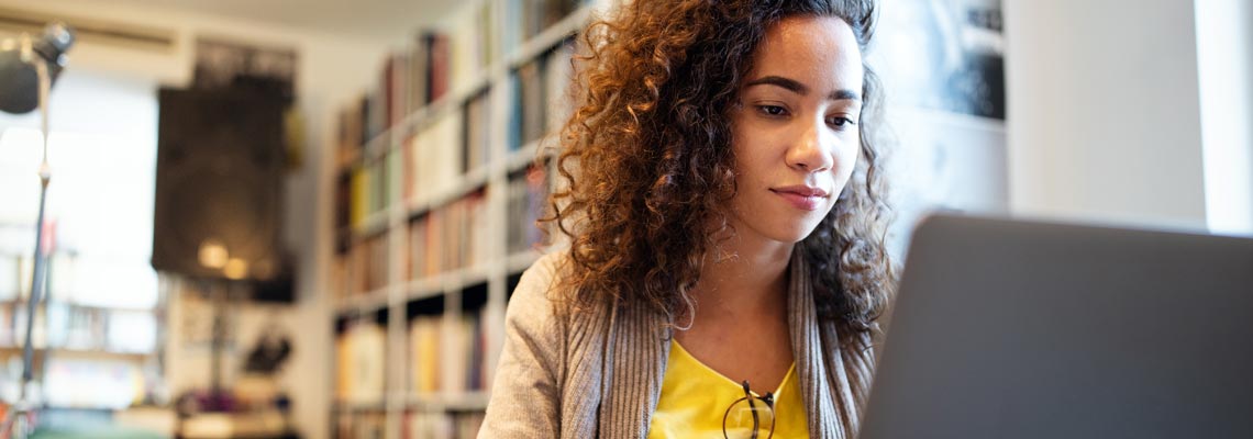 Young student working, learning in college library