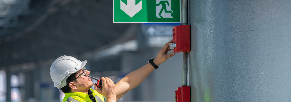 Engineer checking fire alarm emergency system in factory