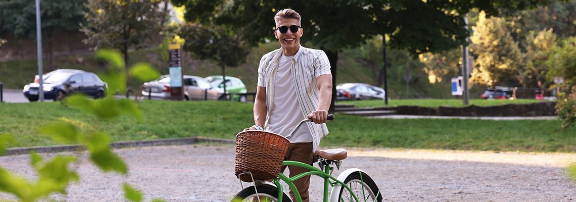 Man walking his bicycle down the street