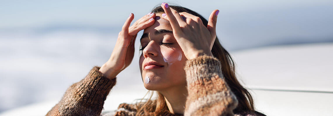 Woman applying sunscreen in the winter