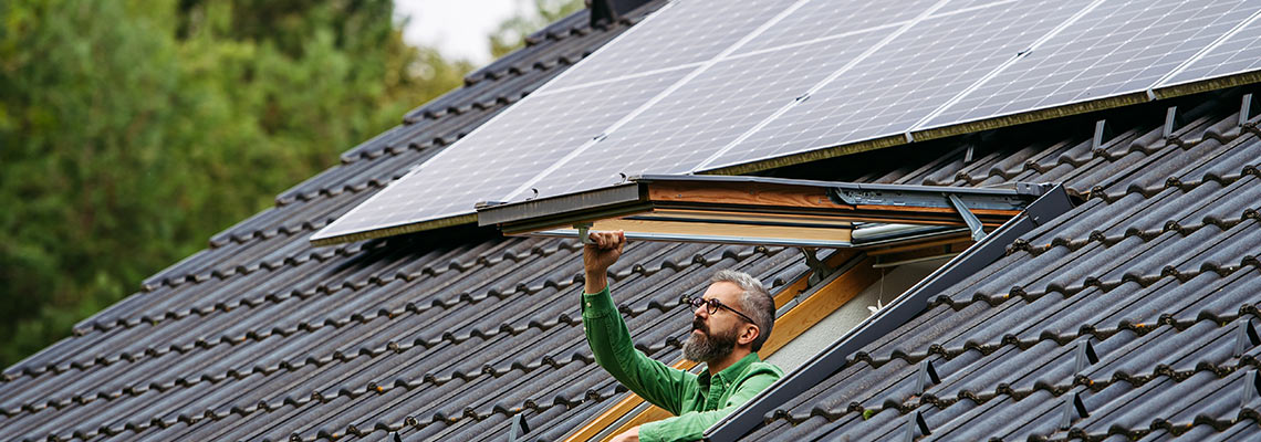 Roof with solar panels and a man in the roof skylight