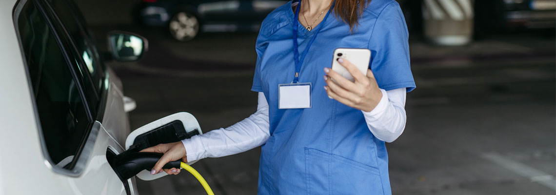 Nurse plugging charger into electric car