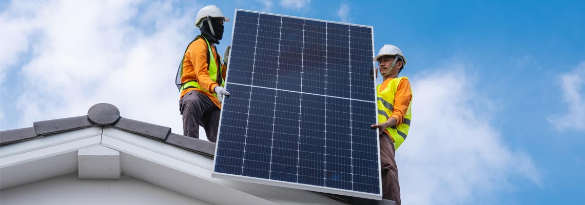 engineers installing solar panels on the roof of house
