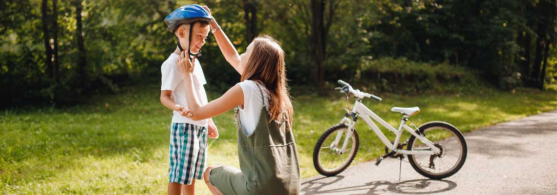 mum securing child's helmet