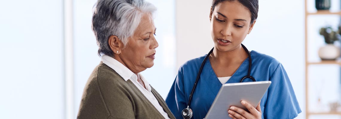 young doctor using a tablet during a consultation with a senior woman