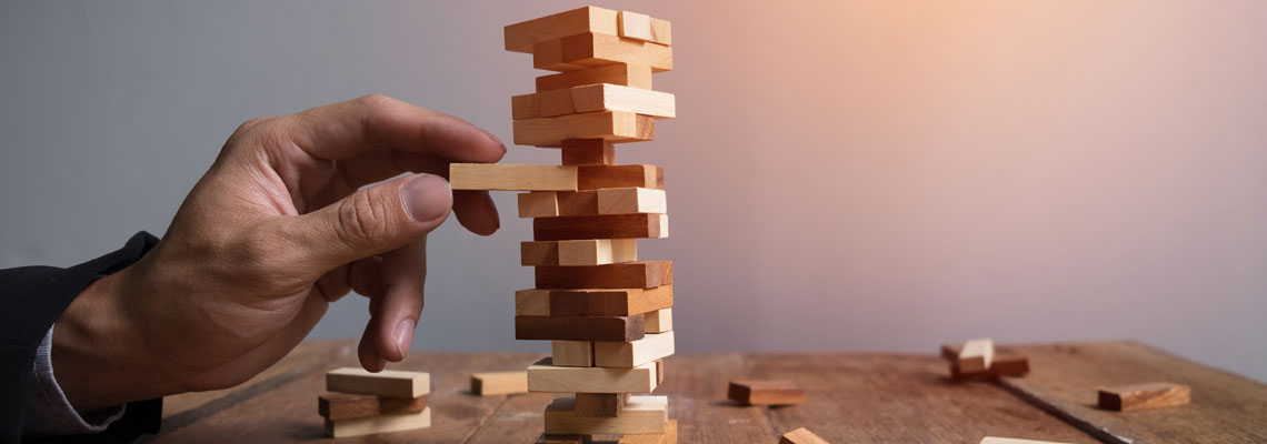 businessman placing wooden block on a tower