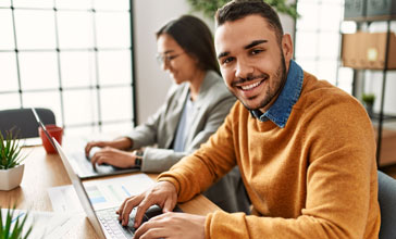 smiling young man working on his laptop