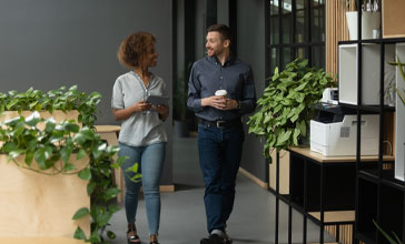 man an woman walking through the office together
