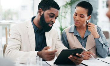 two business people looking at tablet in the office