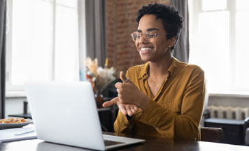 therapist in glasses talking on video call, using sign language