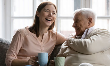 older man having a tea with his daughter