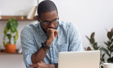 serious man looking at his laptop screen