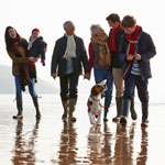 Multi-generation family walking on winter beach
