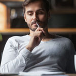man thinking while looking at papers