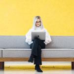 woman sitting on the sofa using laptop