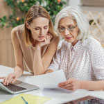 mother and daughter doing bills